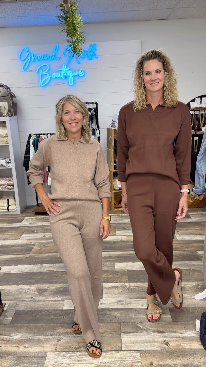 Two women posing in a boutique wearing matching knit loungewear sets.