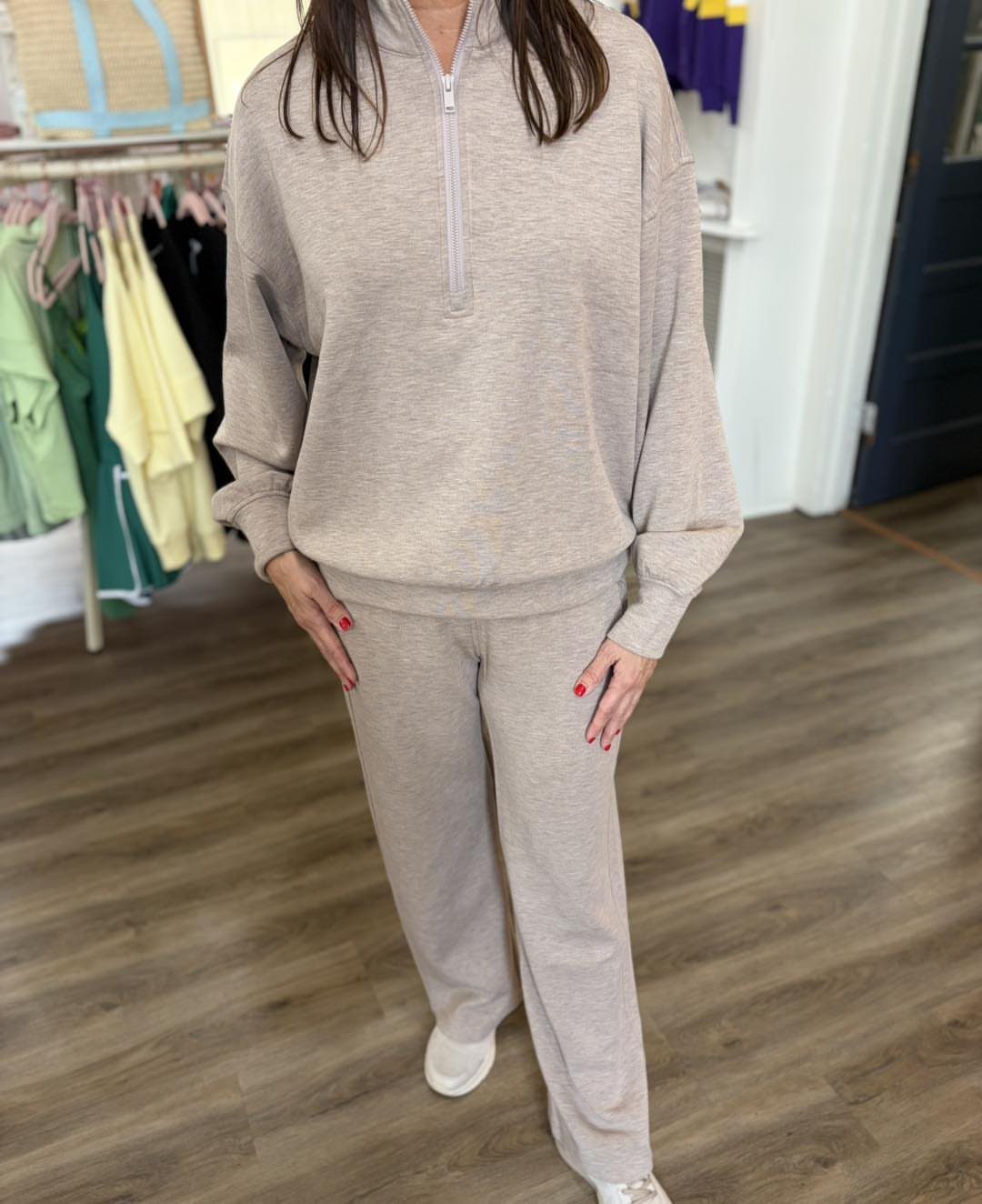 Person wearing a matching beige quarter-zip sweatshirt and wide-leg sweatpants lounge set.