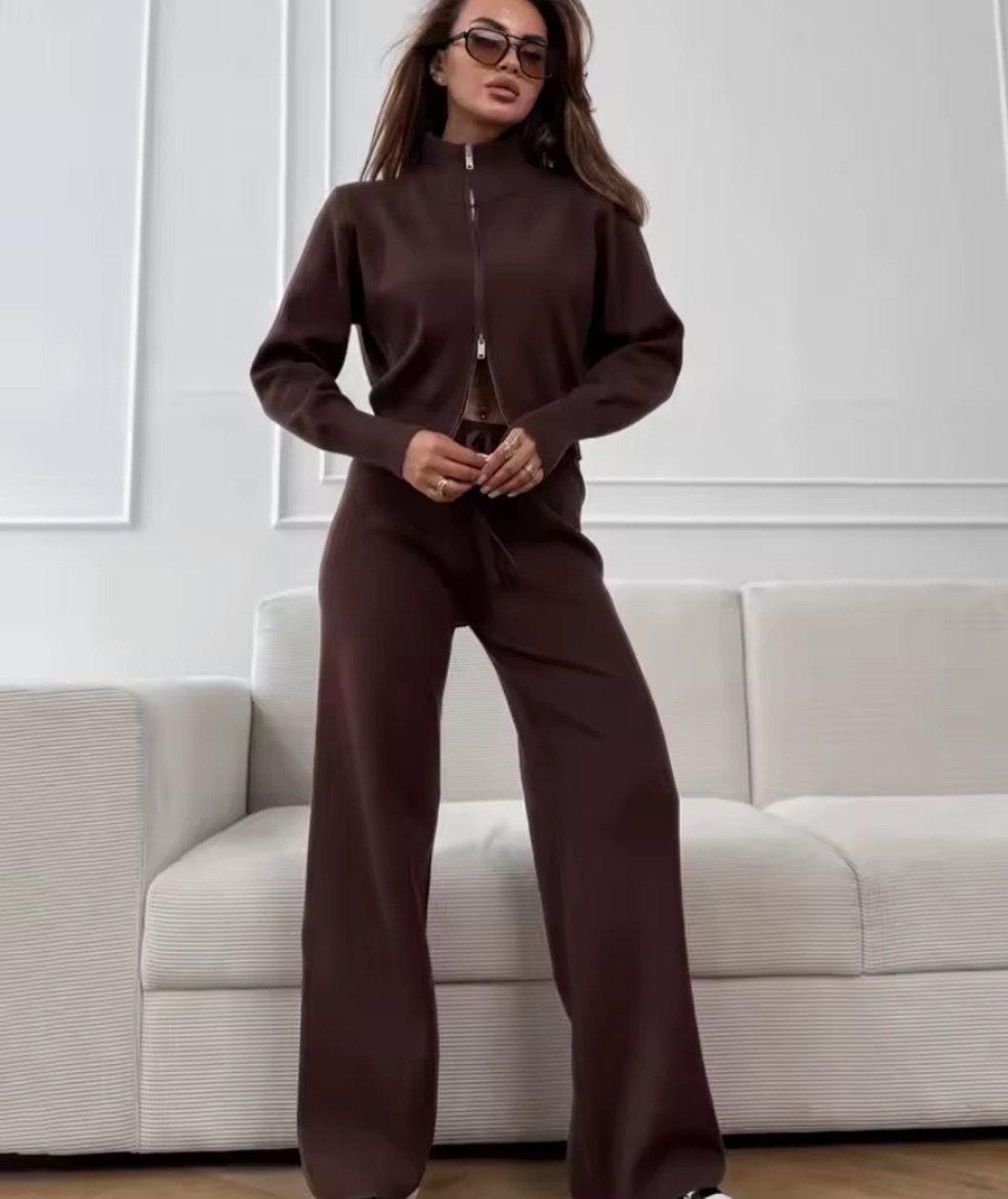 Woman posing in a matching dark brown knit zip-up jacket and wide-leg trousers set.
