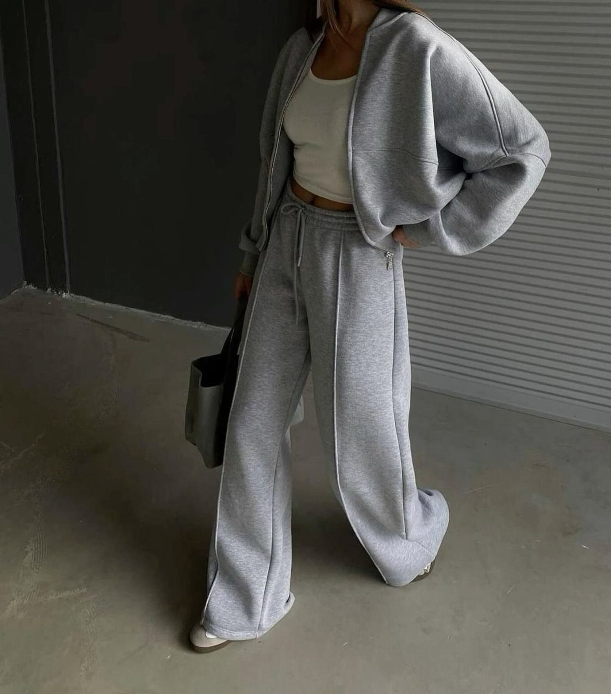 Person wearing a grey monochrome lounge set with wide-leg sweatpants and a cropped sweatshirt.
