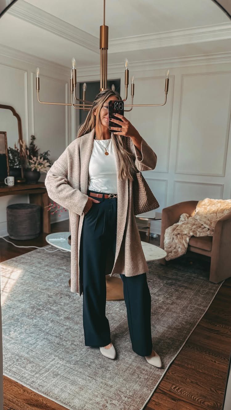 Woman in a mirror selfie wearing a beige cardigan and dark navy wide-leg trousers.