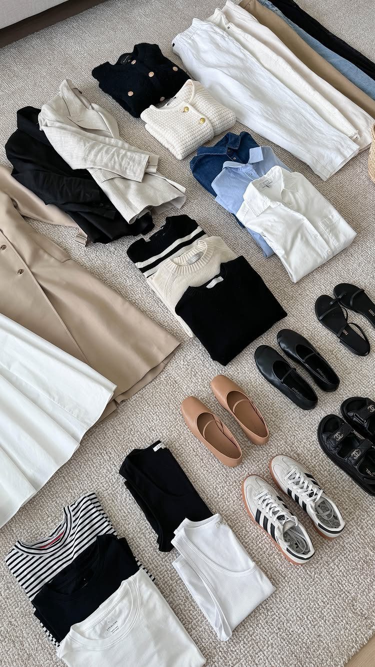 Assorted clothing items and shoes laid out flat on a grey textured surface.