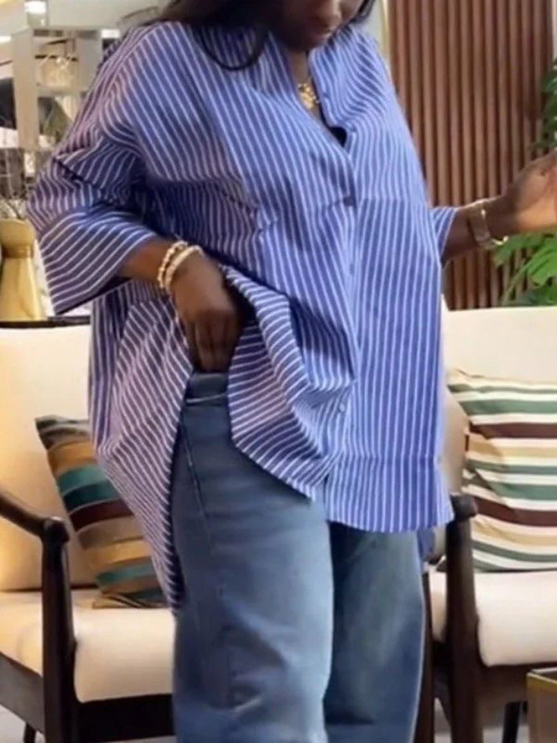 A person wearing a blue and white striped button-down shirt and blue denim jeans.