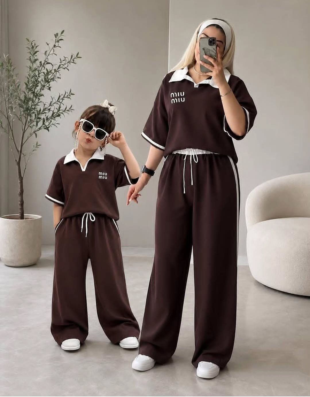 A woman and a child wearing matching brown coordinated two-piece lounge sets.