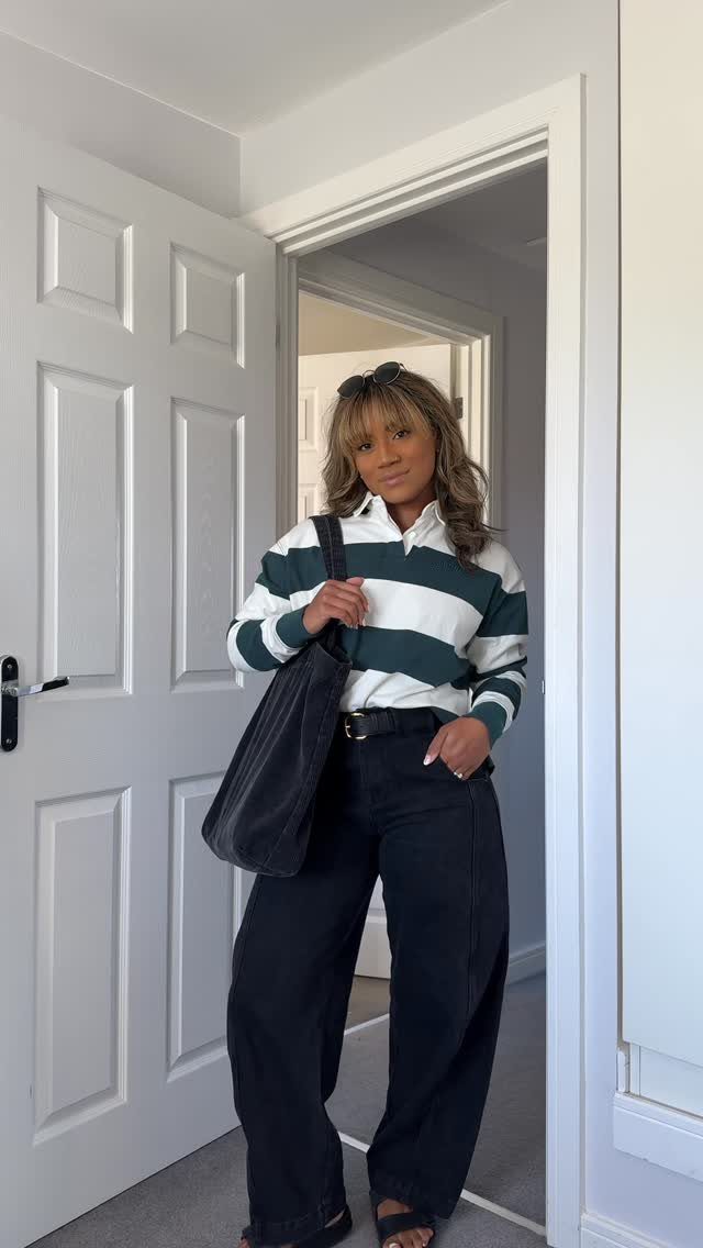Woman wearing a green and white striped rugby polo with black wide leg jeans.